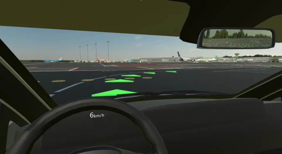 Schiphol VR Driving Simulator: zicht vanuit de cabine met groene routepijlen op de airside